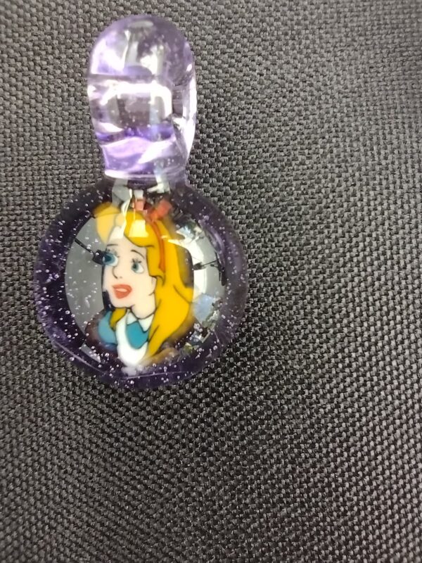 A close up of the face on a purple necklace