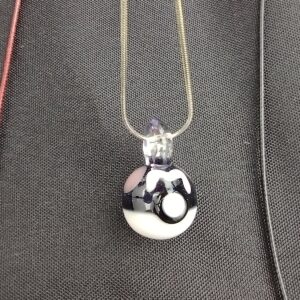 A black and white necklace with a ball on it