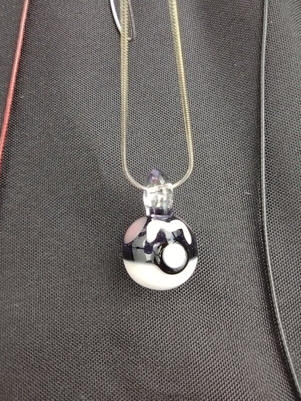 A black and white necklace with a ball on it