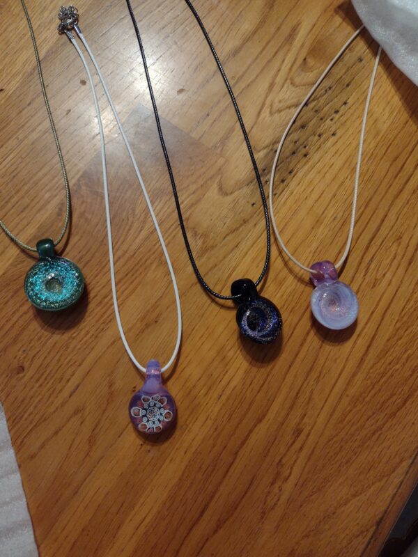 A group of necklaces sitting on top of a wooden table.